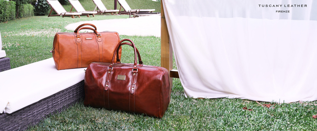 Two brown leather travel bags displayed beside outdoor seating